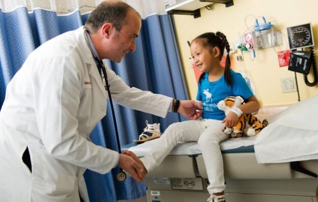 a doctor examines a child with osteoarthritis of the hip